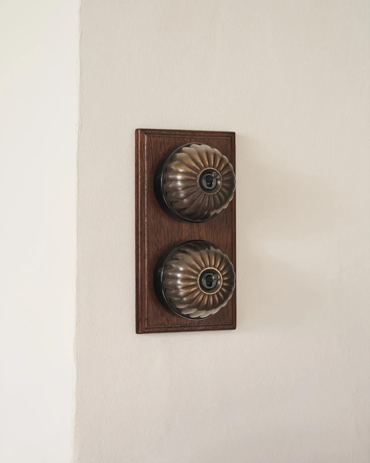 A pair of deVOL Jelly Toggle Switches in our 'Oxidised Brass' finish and fitted to a richly stained Sapele pattress.