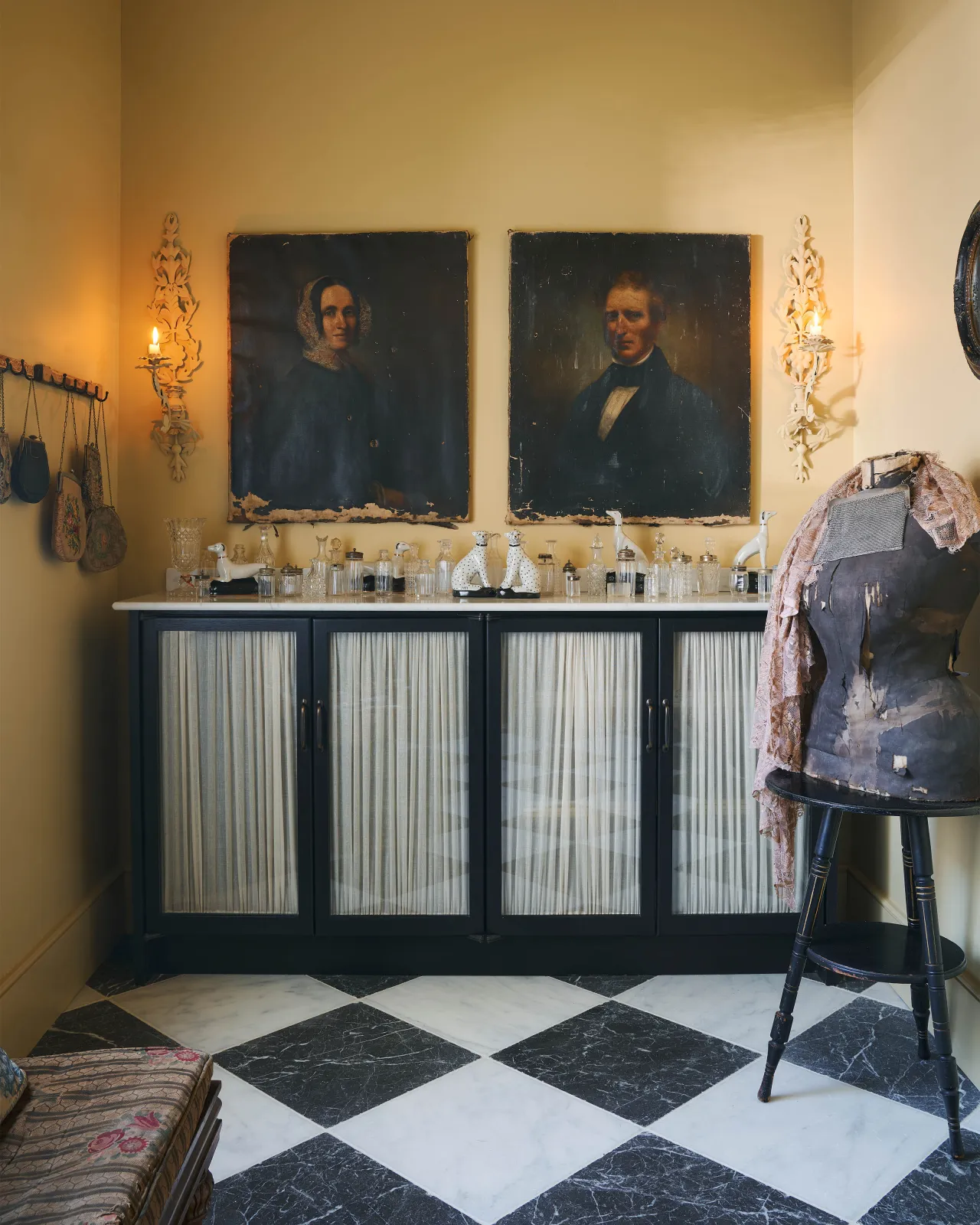 A black and white chequered marble floor with vintage cupboards and decorations.
