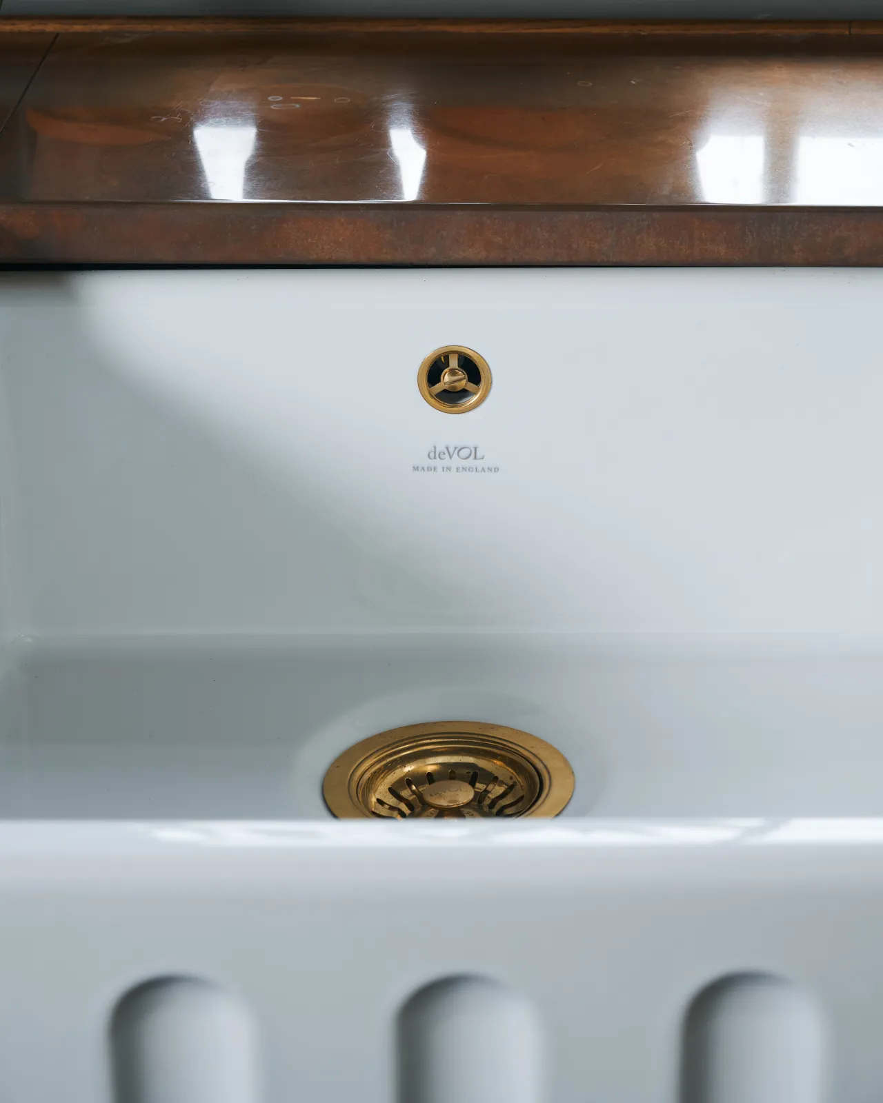 A close-up straight-on view of a fluted ceramic Belfast sink.