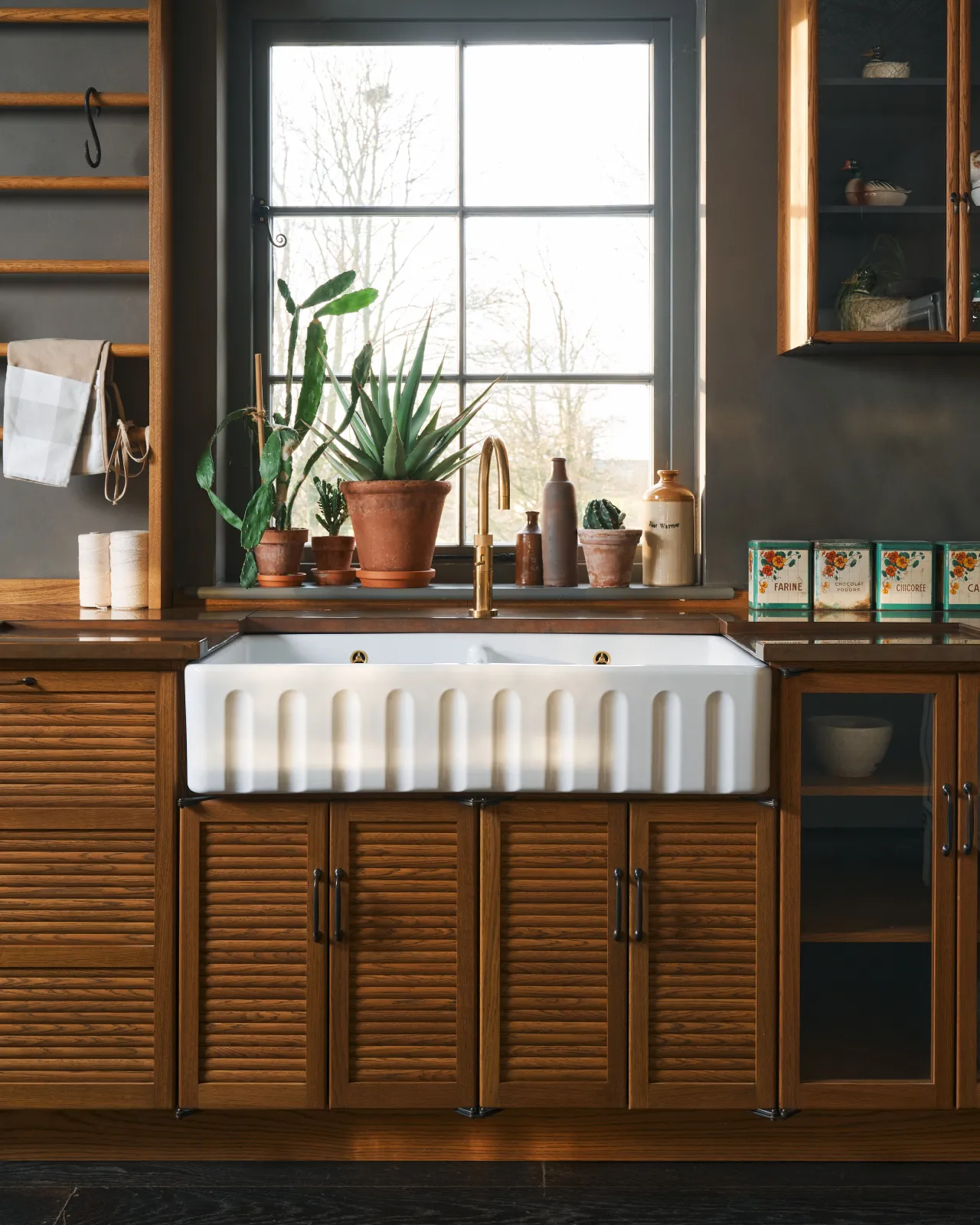 A straight-on view of an extra large double bowl fluted ceramic Belfast sink in mid-century-style oak kitchen.
