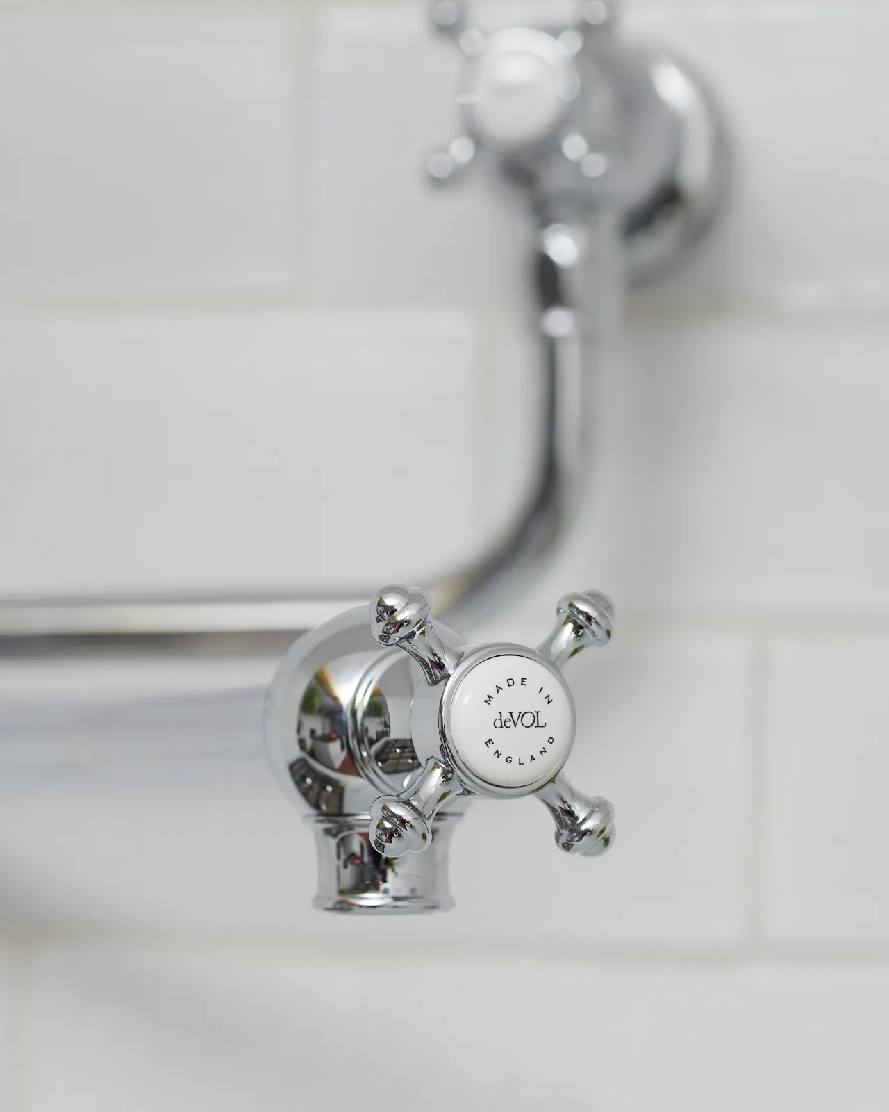 A close-up view of the crosshead handle at the spout of a traditional-style chrome pot filler tap, a 'deVOL' logo can be seen in the centre of the handle.