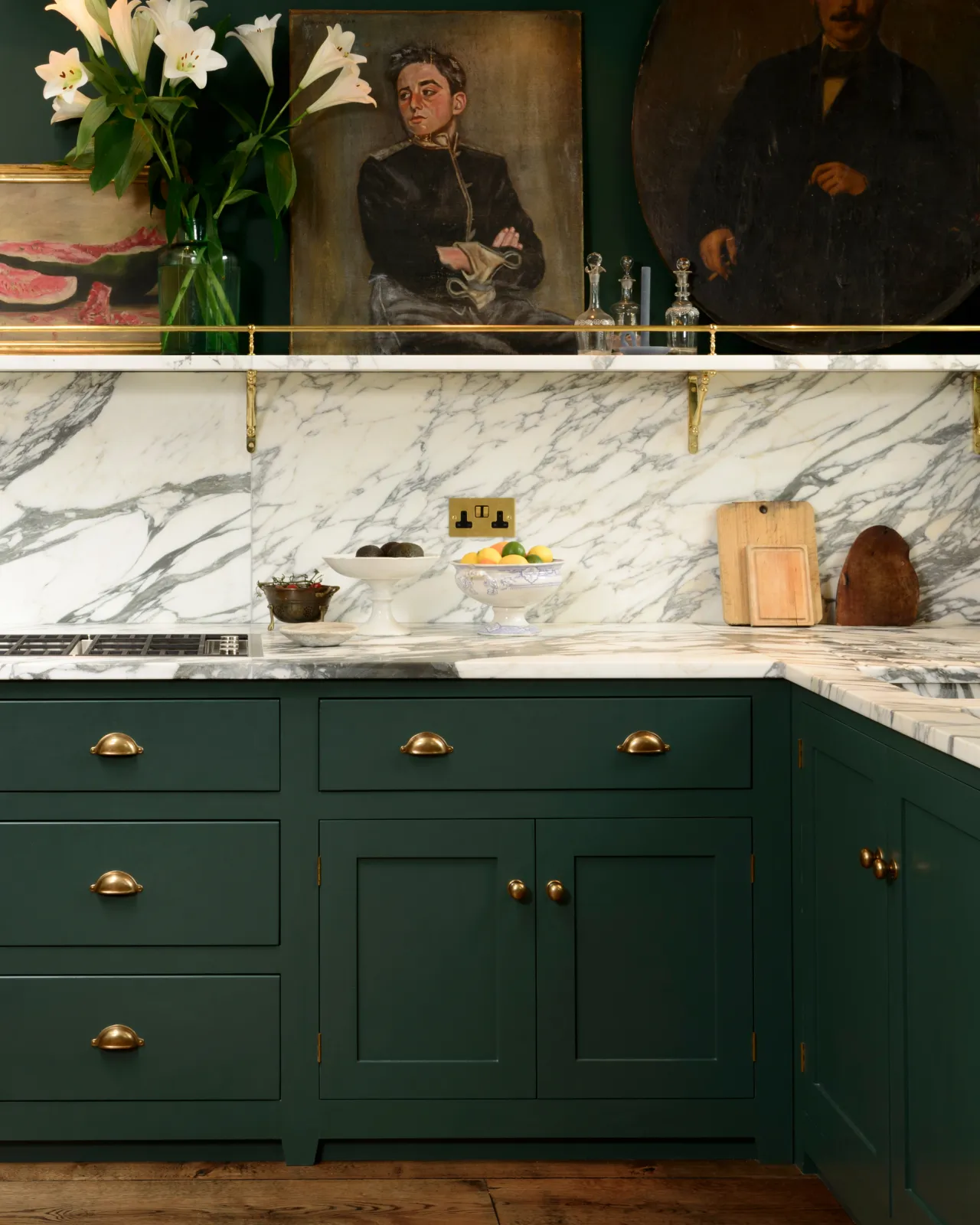A straight-on view of a racing green painted Georgian-style kitchen with simple cup handles and round doorknobs in a burnished 'Bella' brass finish.