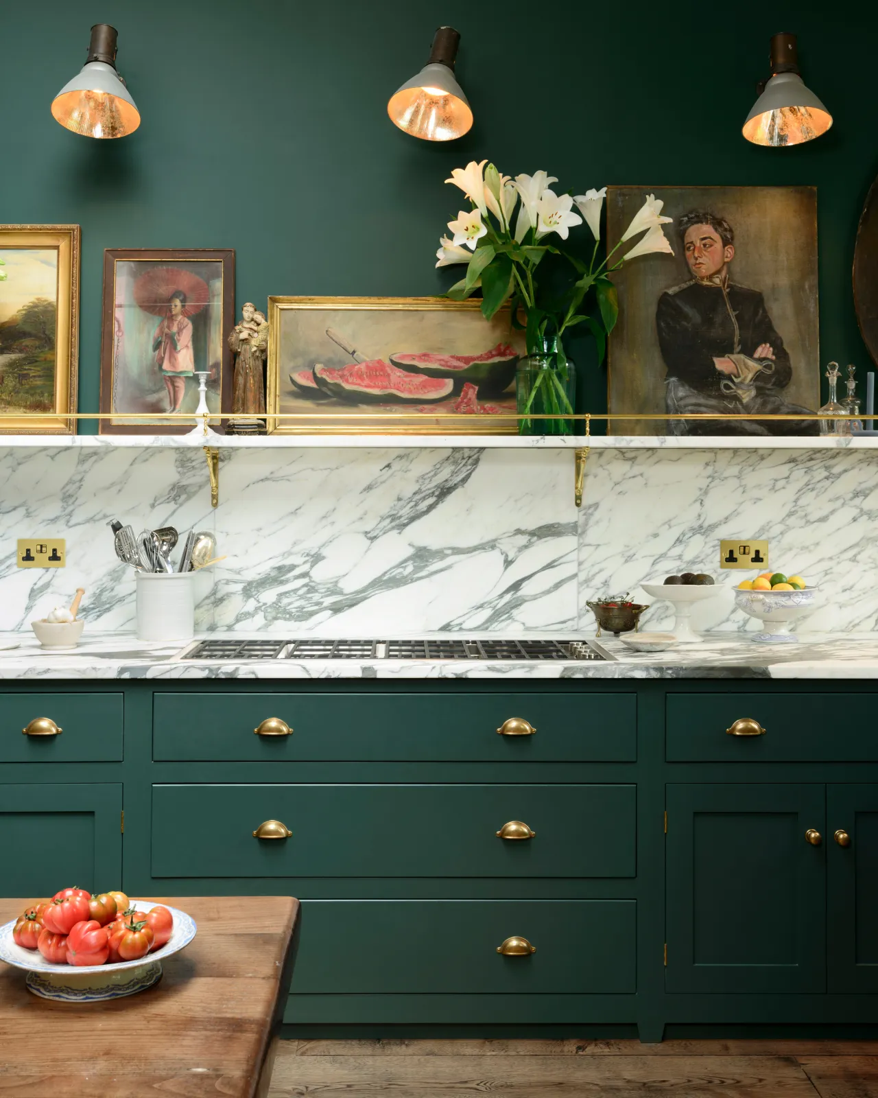Racing green painted Georgian-style kitchen cupboards with an Arabescato marble worktop and splashback and fitted with Georgian-style cup handles in a burnished 'Bella' brass finish.
