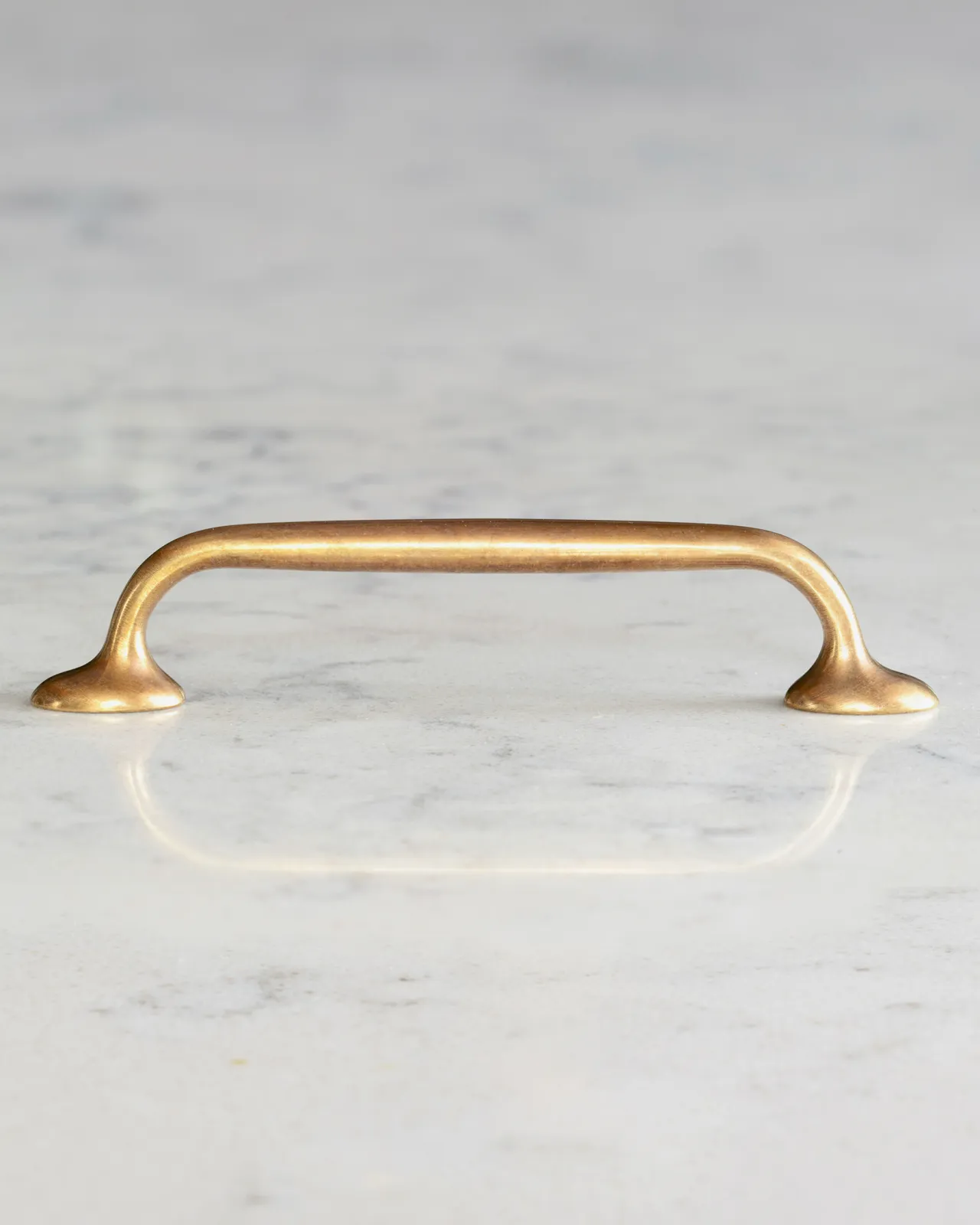 A profile view of a simple pull handle for a kitchen cupboard or drawer in a burnished 'Bella' brass finish.