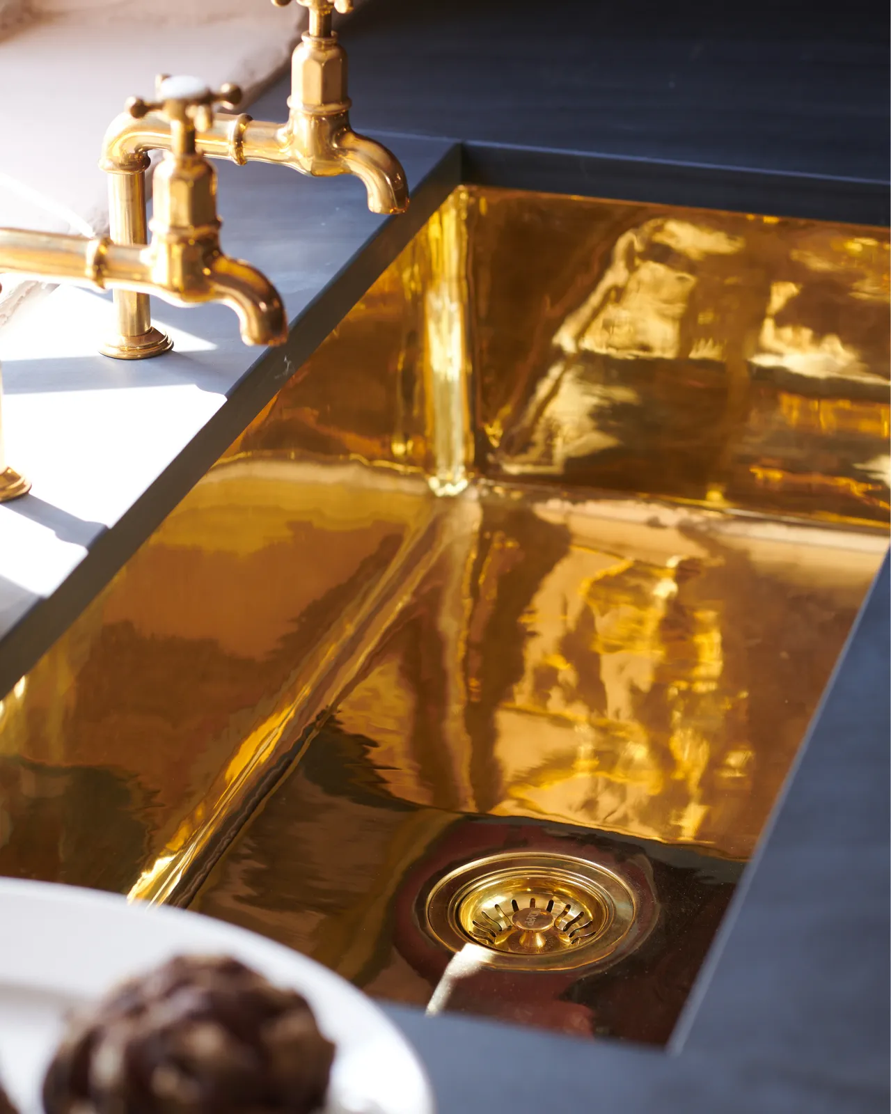 An overhead view of a large undermounted polished brass sink.