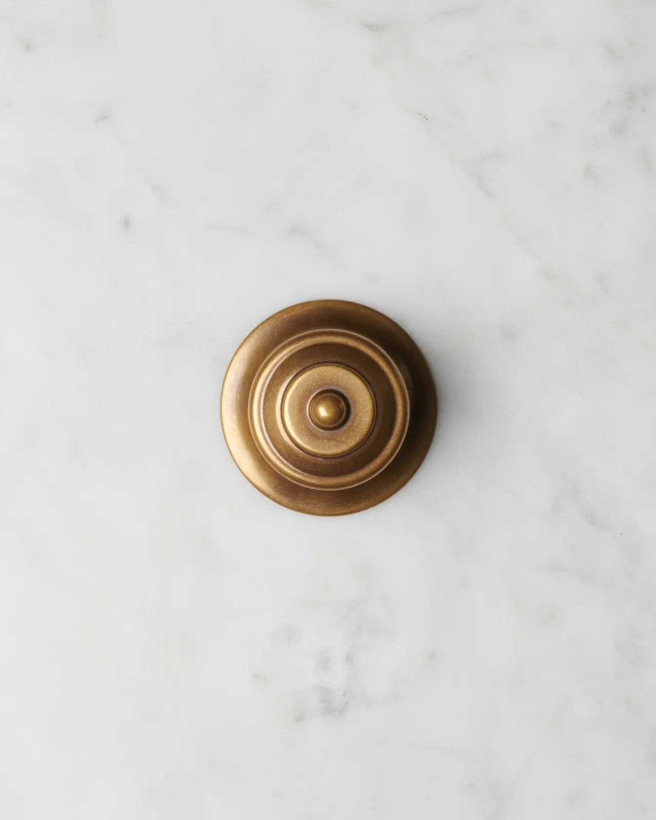 An overhead view of a Victorian-inspired ornate doorknob in a warm burnished brass finish.
