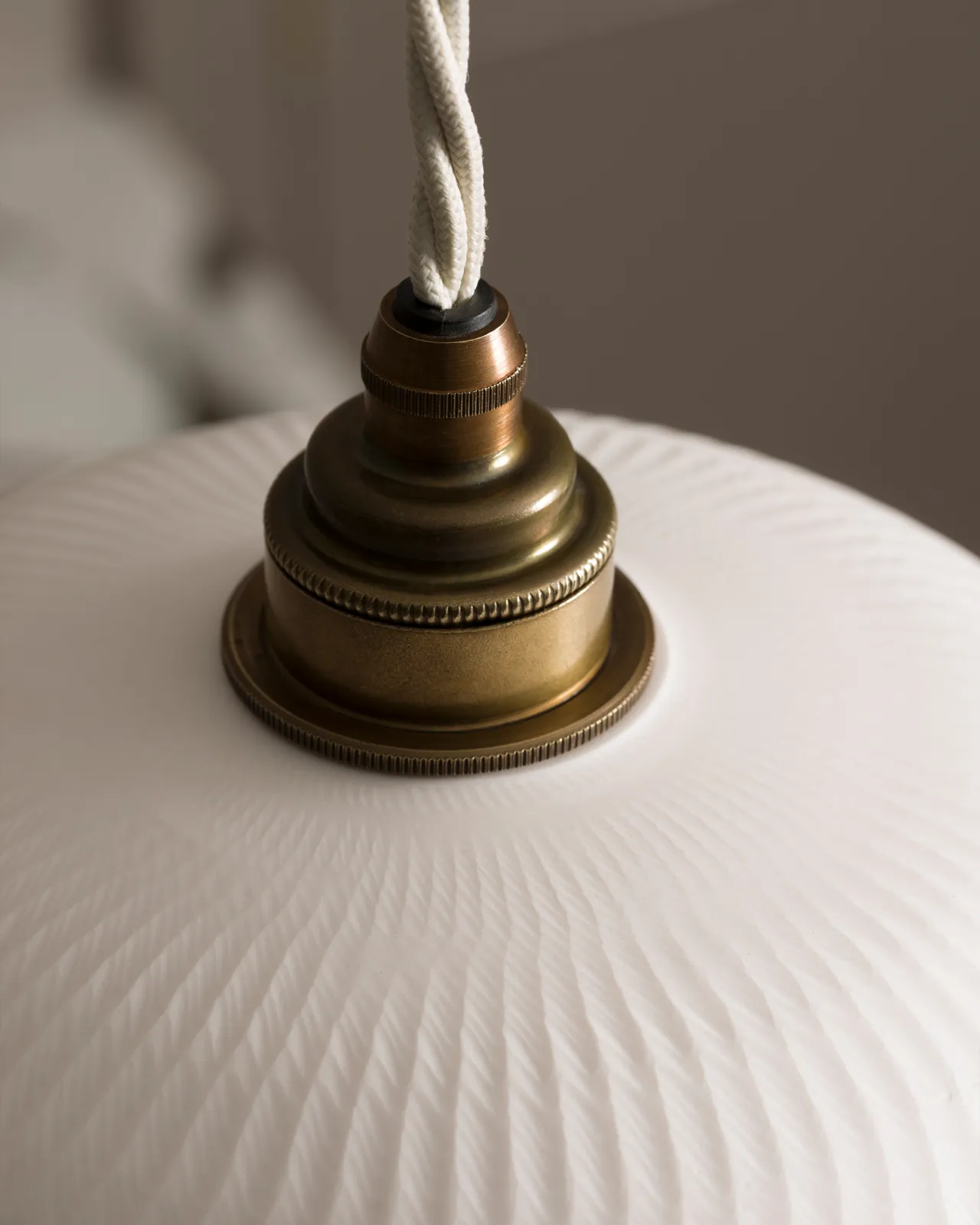 A close-up view of an unglazed chattered skullcap porcelain pendant light.
