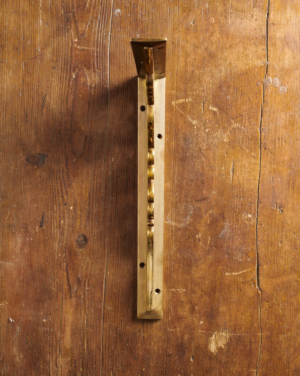 A front profile view of a large Victorian-inspired ornate shelf bracket in an aged brass finish.
