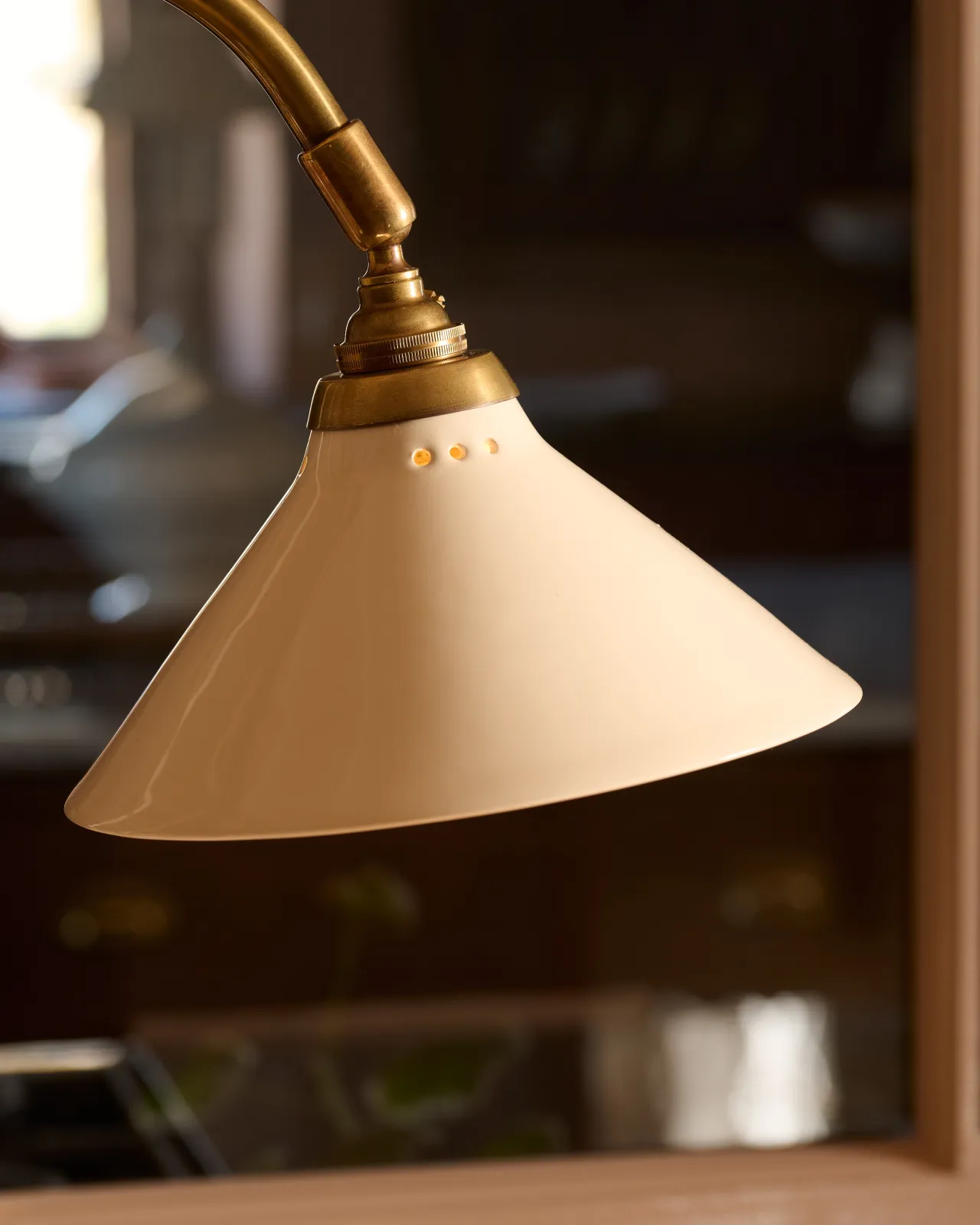 A close-up view of a small cream glazed ceramic light shade.