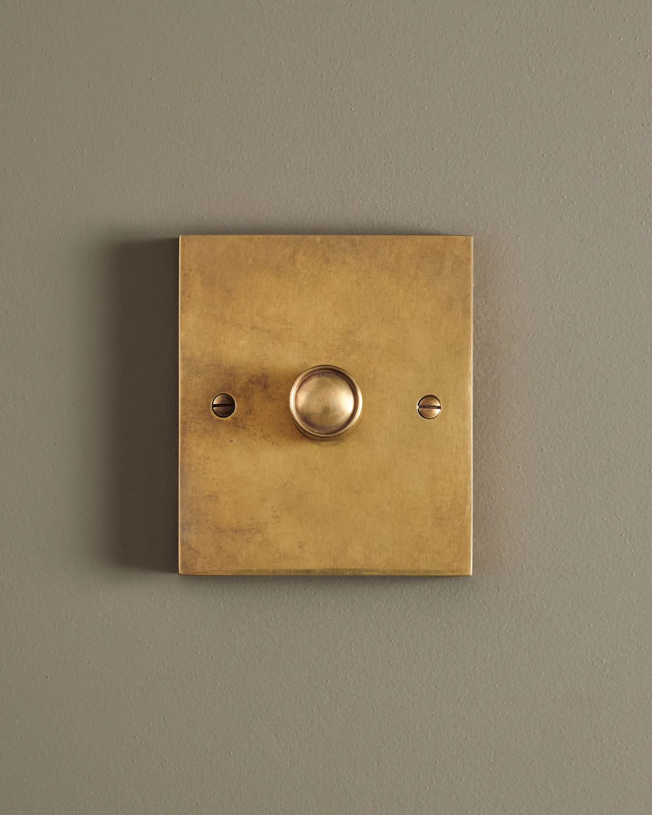 A straight-on view of a 1 gang box dimmer switch in a warm burnished brass finish.