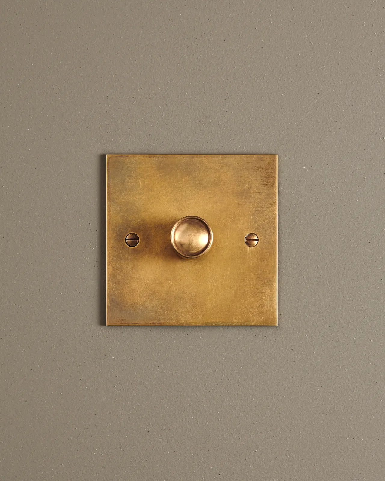 A straight-on view of a 1 gang classic dimmer switch in a warm burnished brass finish.