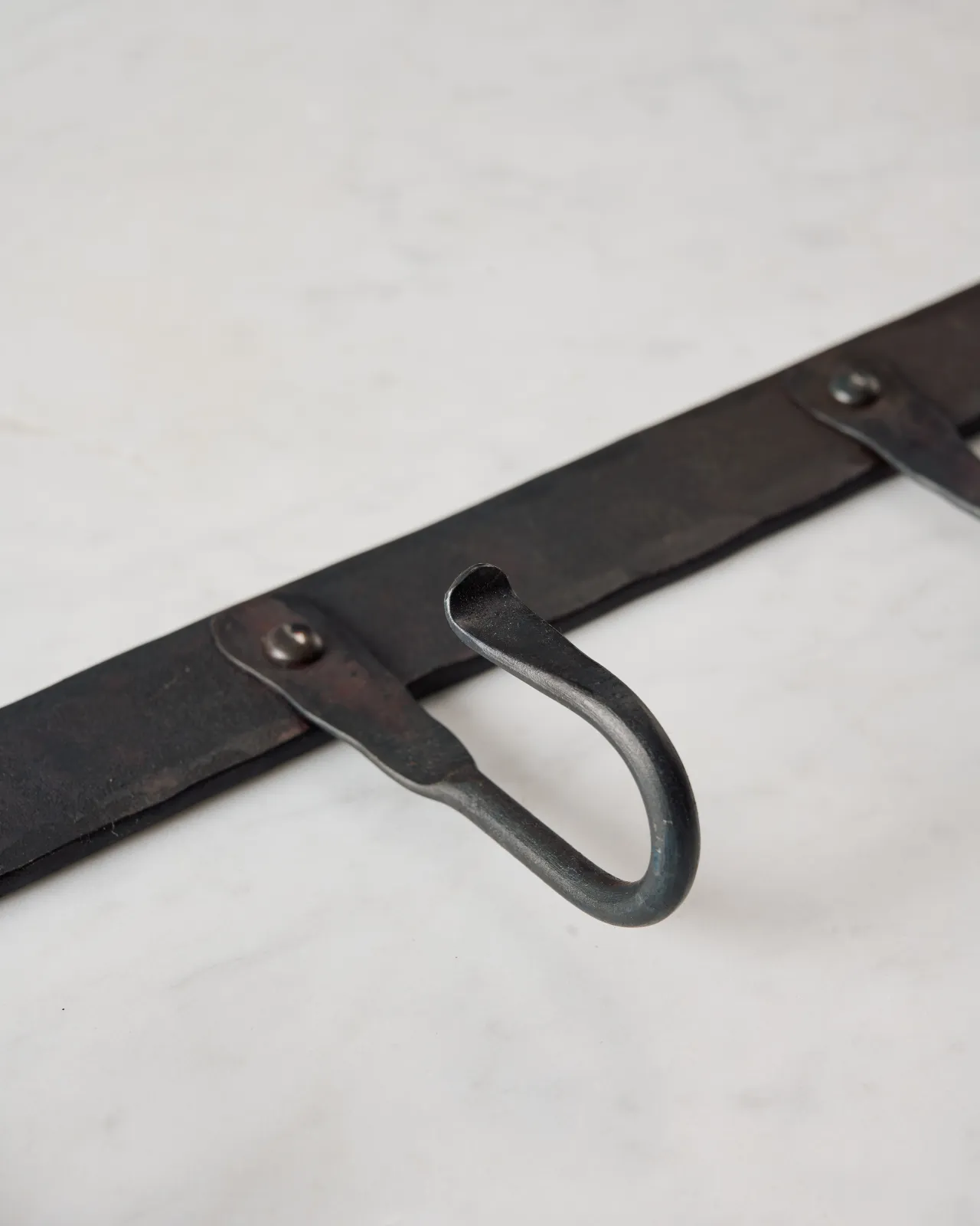A close-up oblique view of a hook on a wrought iron hook rack.