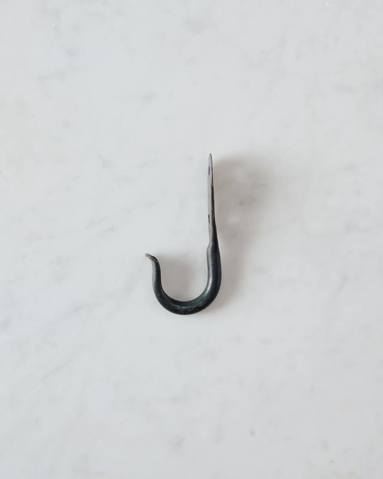 A side profile view of a large iron wall hook.