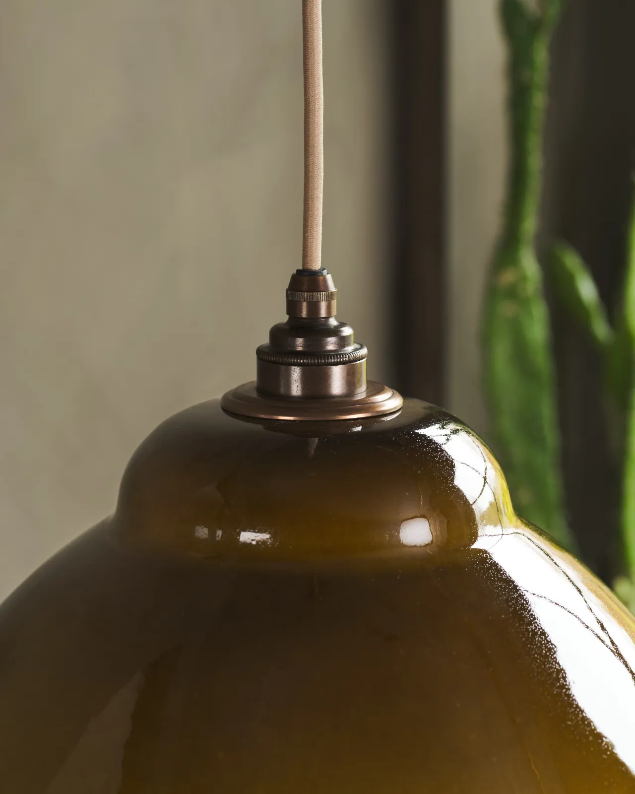 A close-up view of a mid-century-style sepia glazed ceramic light shade.