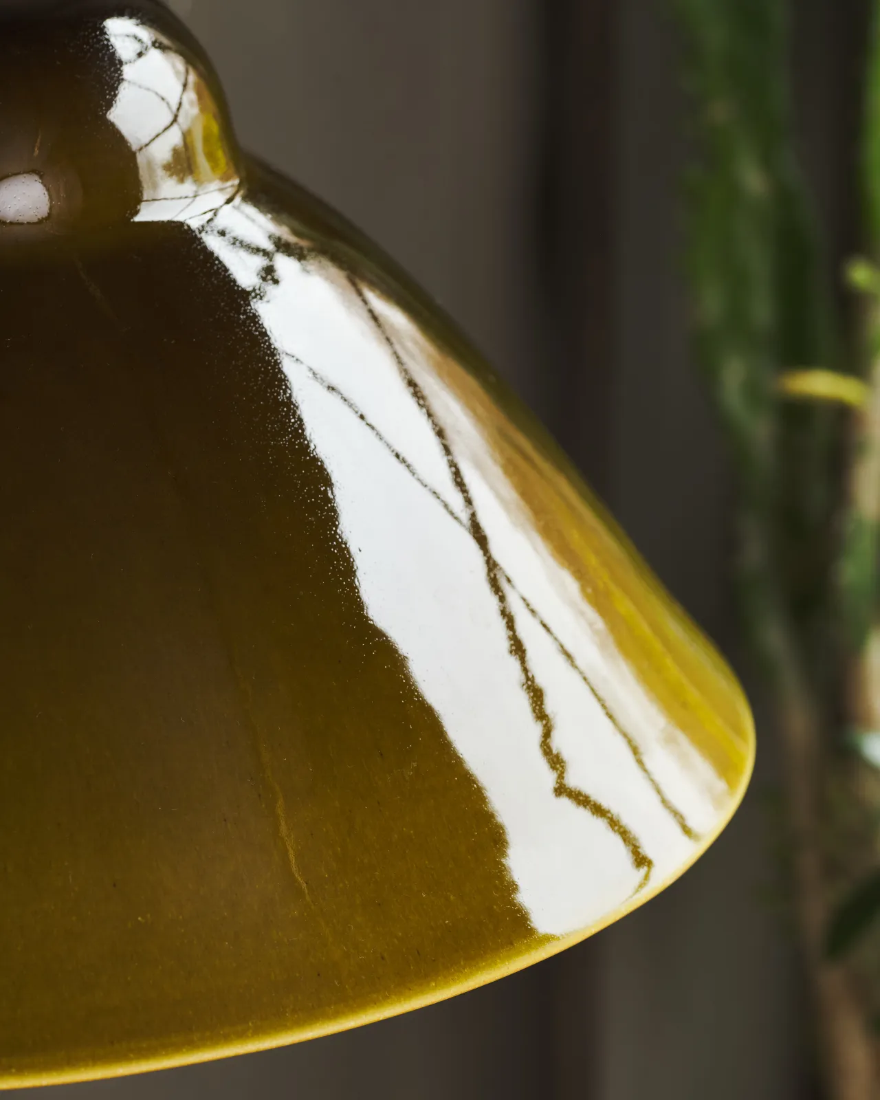 A close-up view of the rim of a mid-century-style sepia glazed ceramic light shade.
