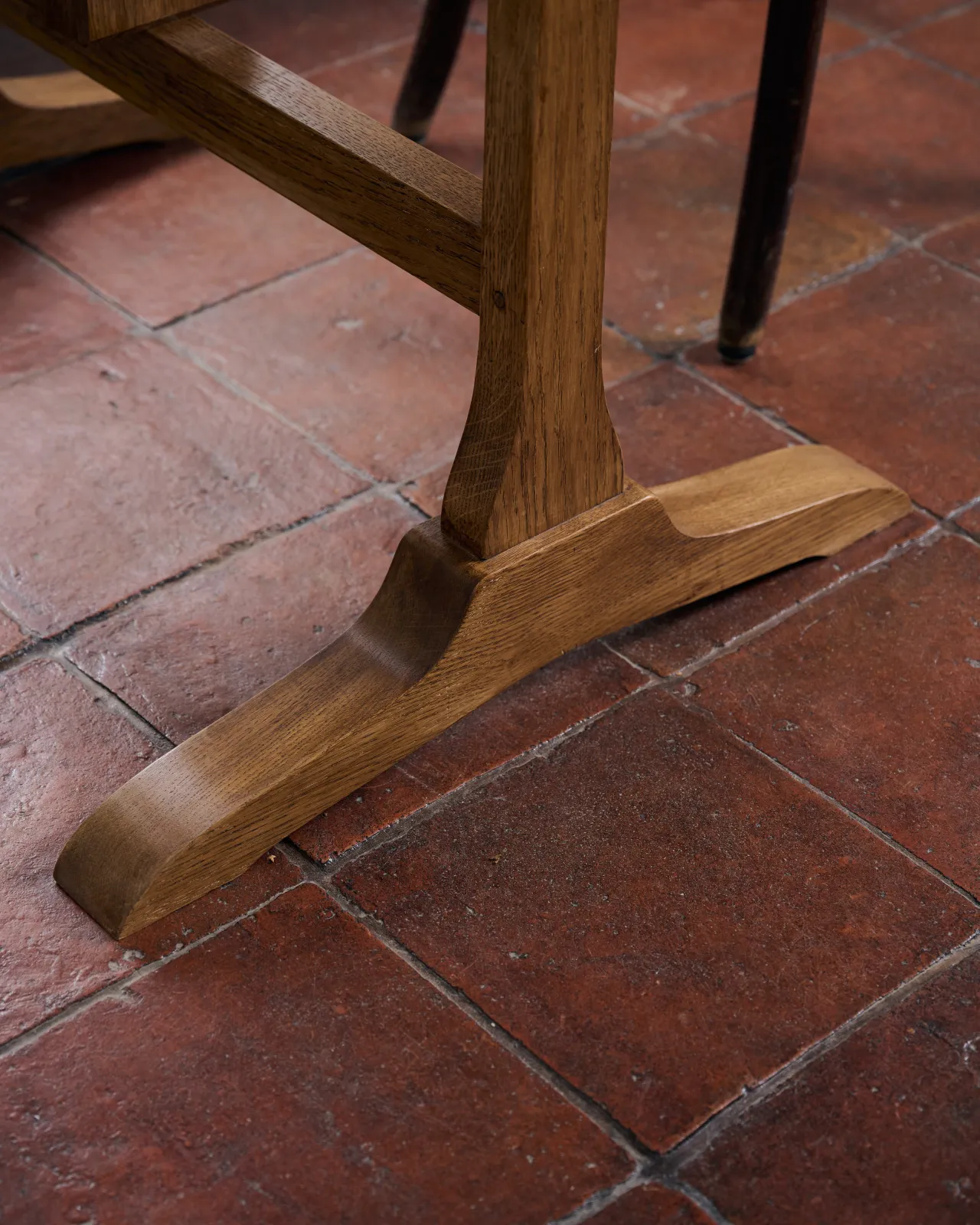 A close-up view of a table leg and foot from a pine dining table.