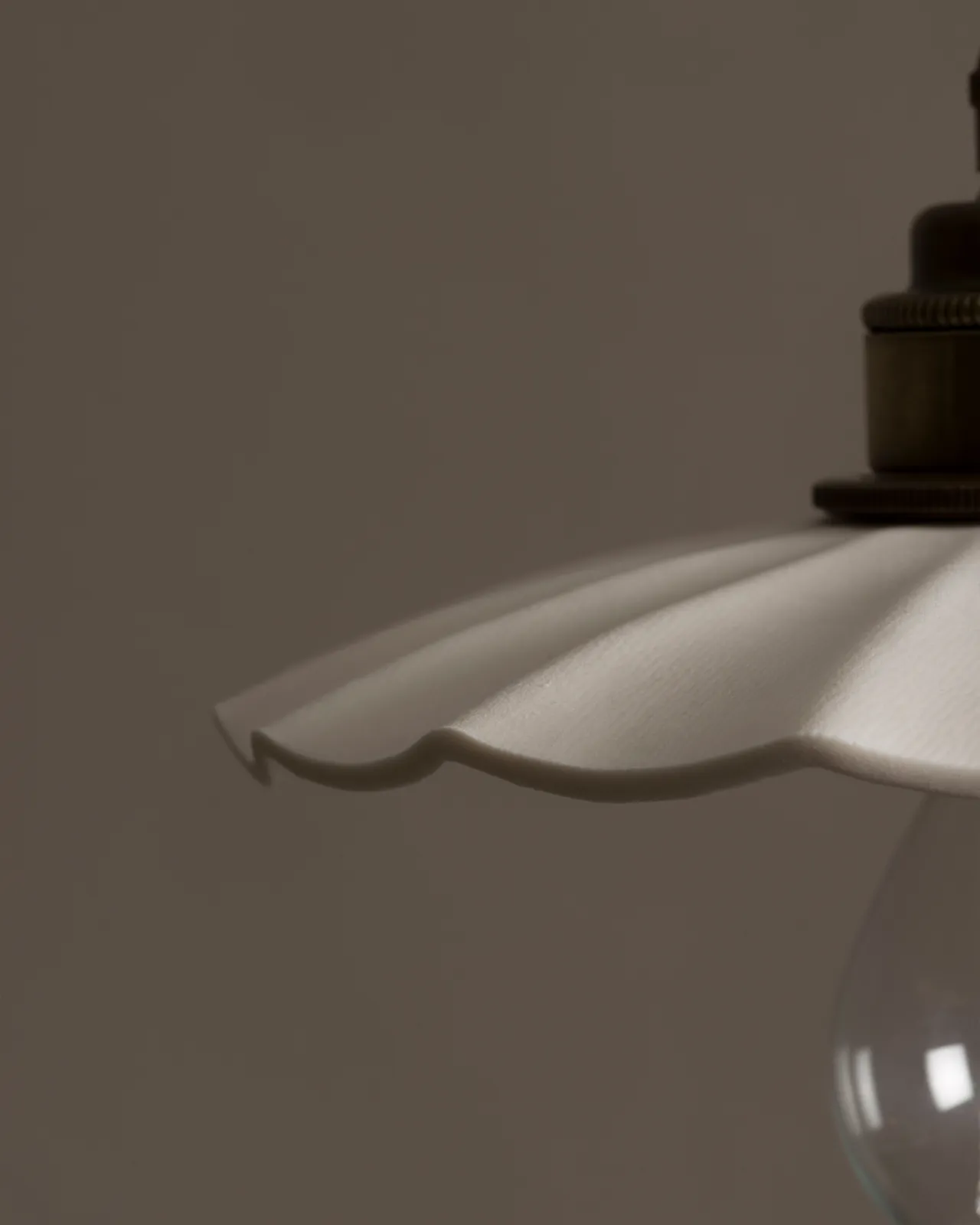 A close-up view of an unglazed porcelain pendant light with wide pleats.