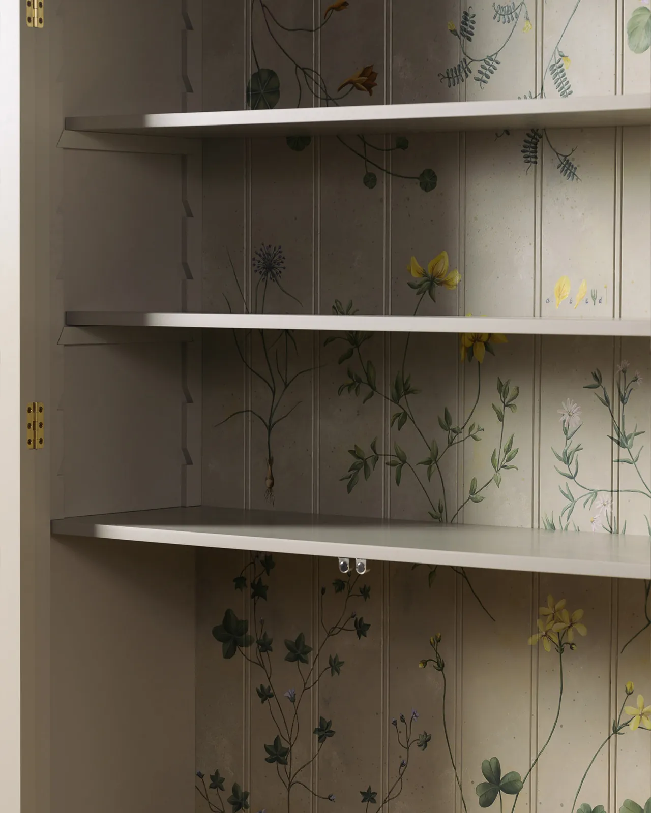 An oblique view of the interior of a display cabinet with a cream interior and traditional painted botanical plants and motifs on the tongue and groove back panel.