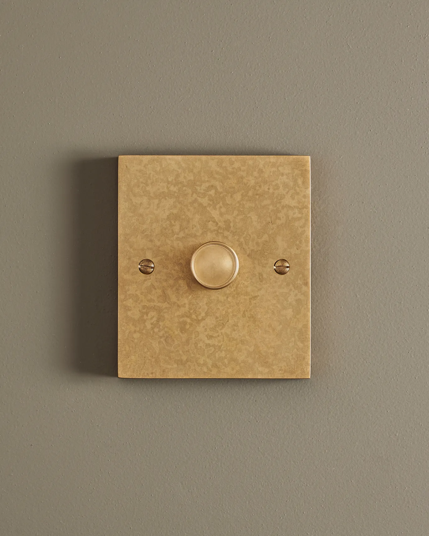 A straight-on view of a 1 gang box dimmer switch in a mottled aged brass finish.