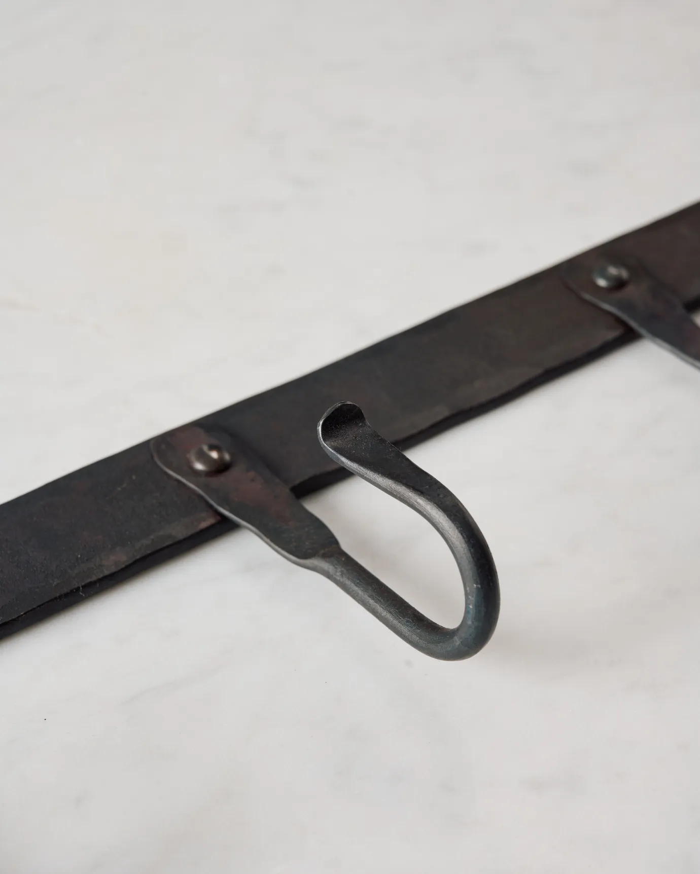 A close-up oblique view of a hook on a wrought iron hook rack.