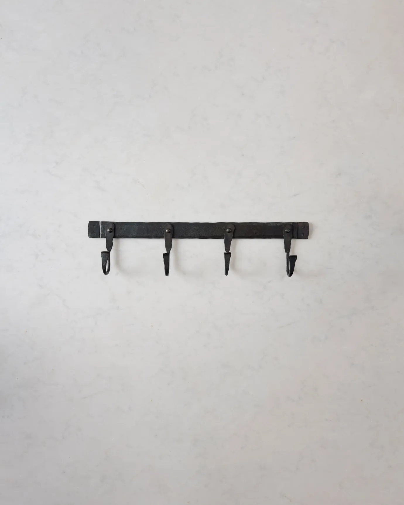 A medium iron hook rack with four hooks spread evenly across the length.