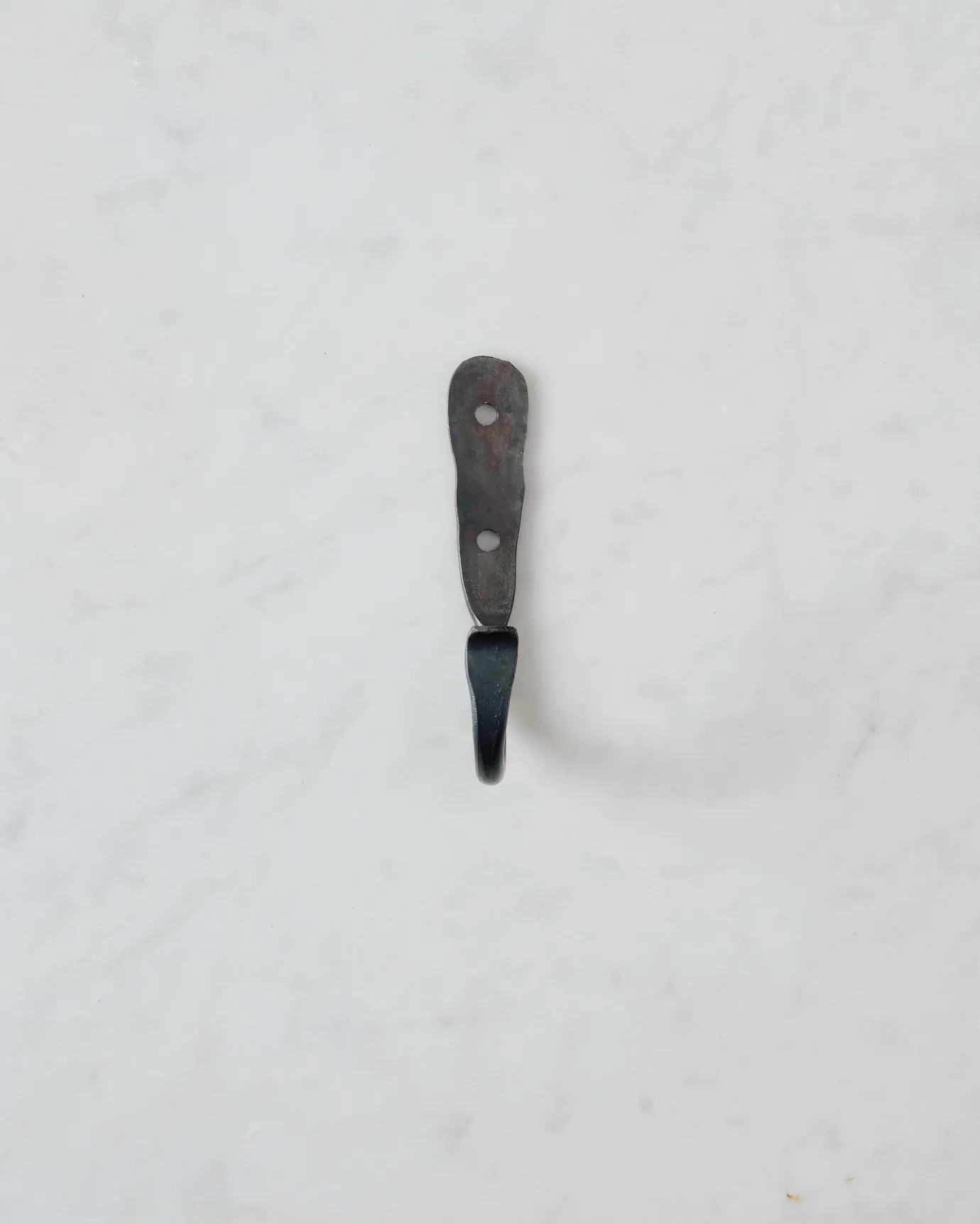 A front profile view of a small iron wall hook.