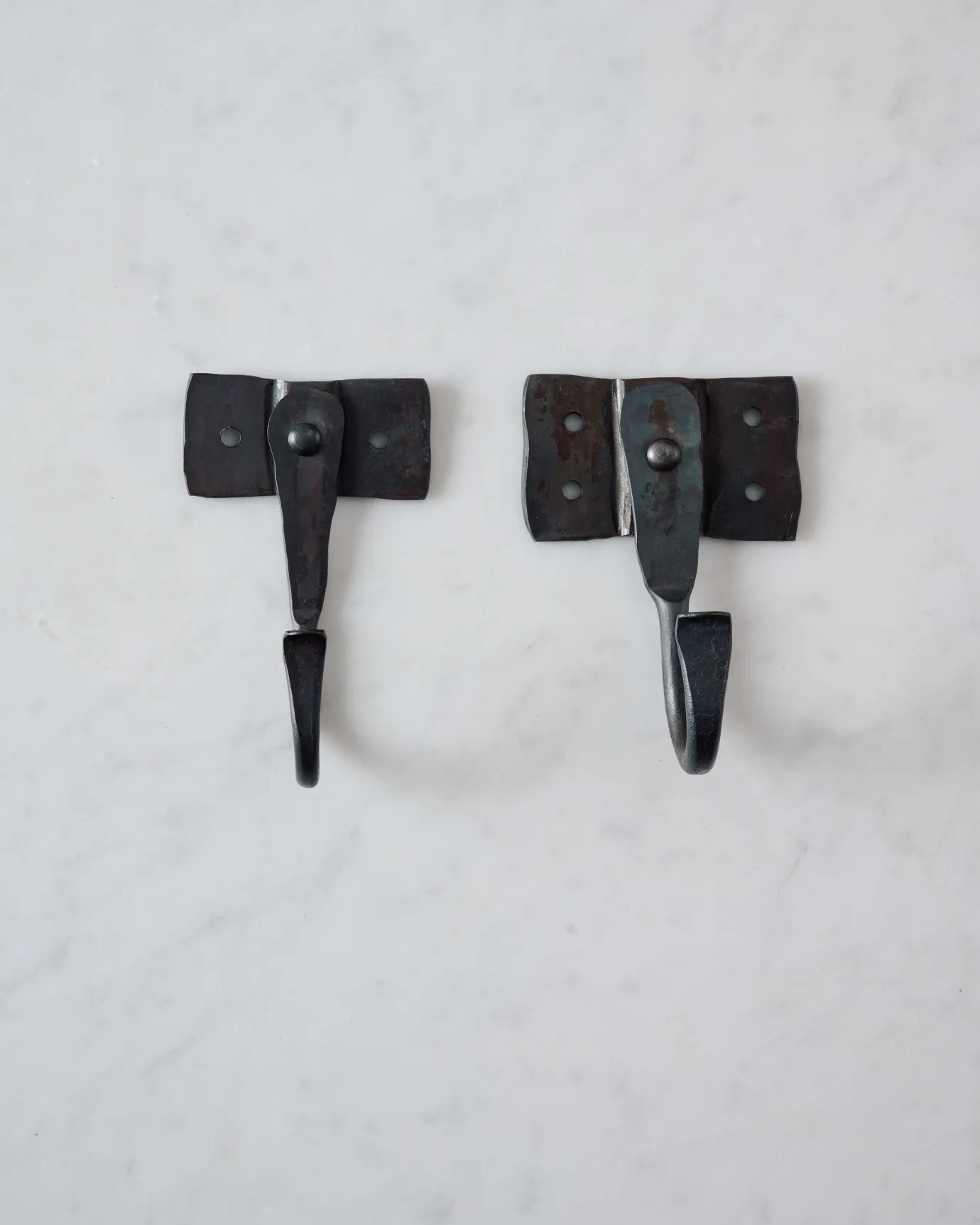 Two iron wall hooks with square-shaped backplates, one small and one large.